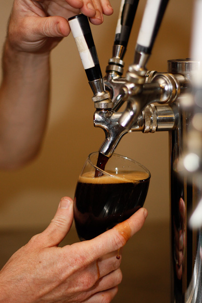 Dark beer being poured from a tap